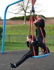 Two children playing on park equipment
