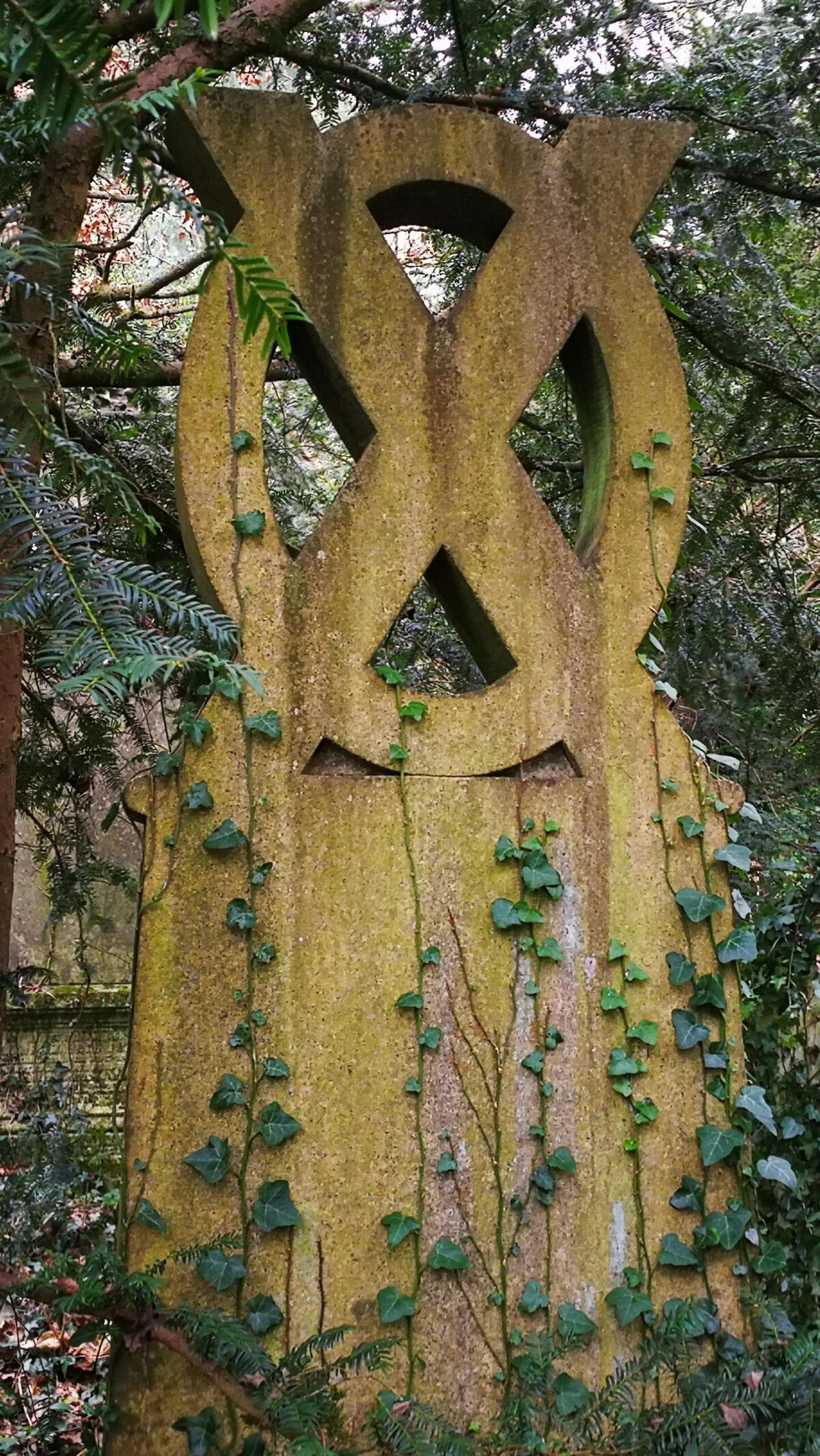 Beautiful carved circular topped memorial stone Covered by ivy Old Barnes Cemetery