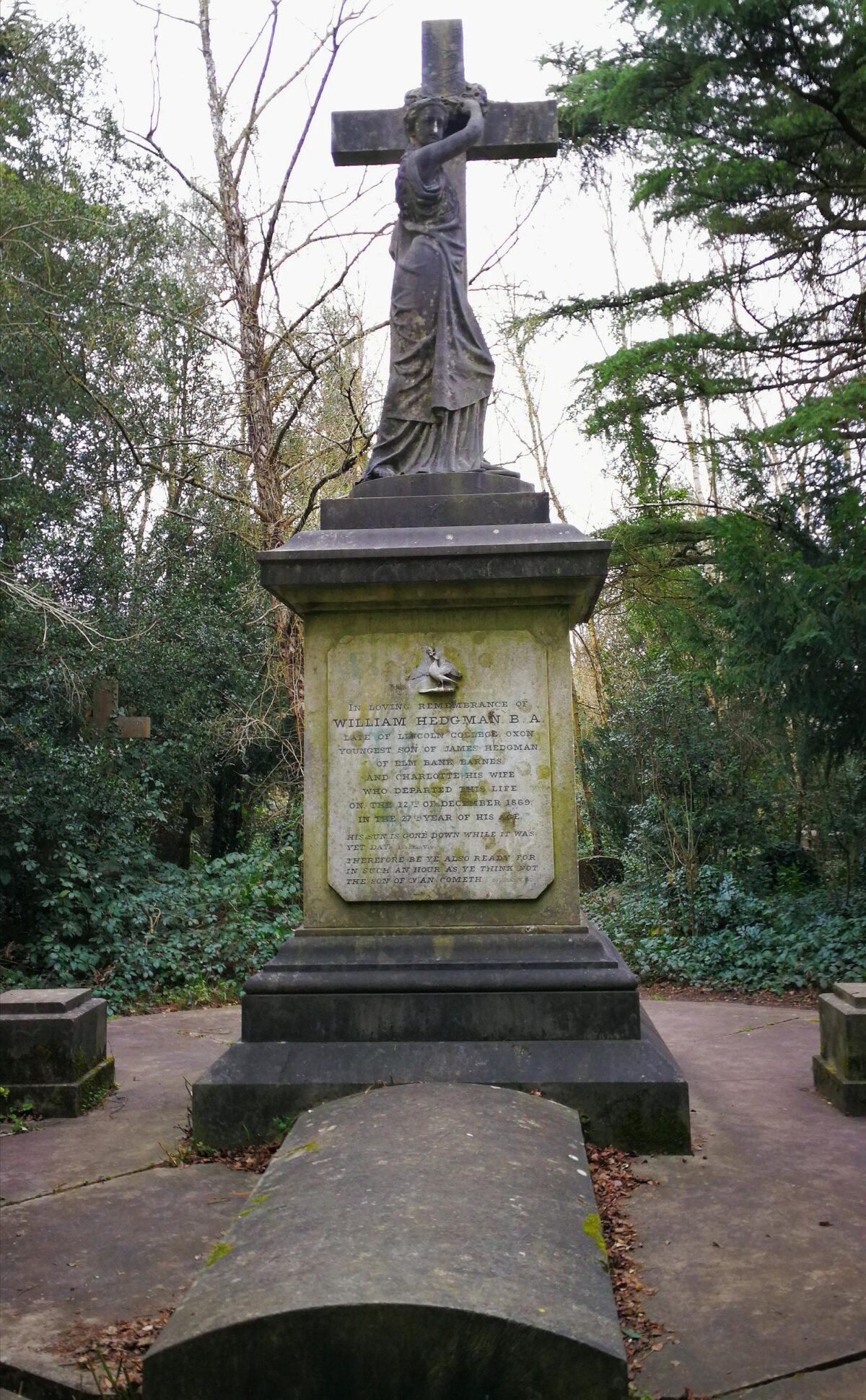 Stone cross with a stone statue for William Hadgman BA Old Barnes Cemetery